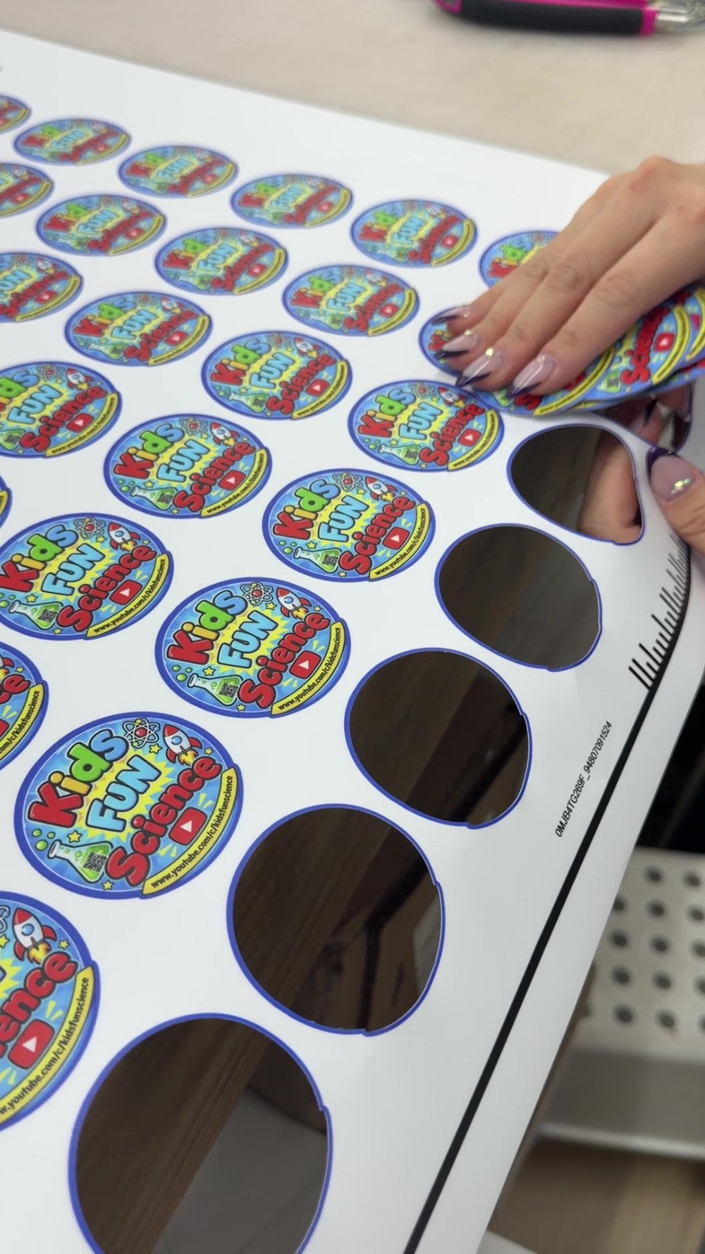 Colorful custom stickers being peeled from a printed sheet