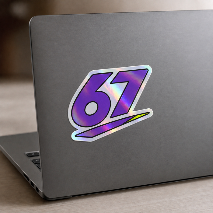 Sample mockup of a purple 67 holographic sticker applied to a charcoal laptop.