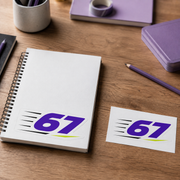 Sample mockup of a purple 67 kiss cut sticker on a white sketchbook beside its backing card.